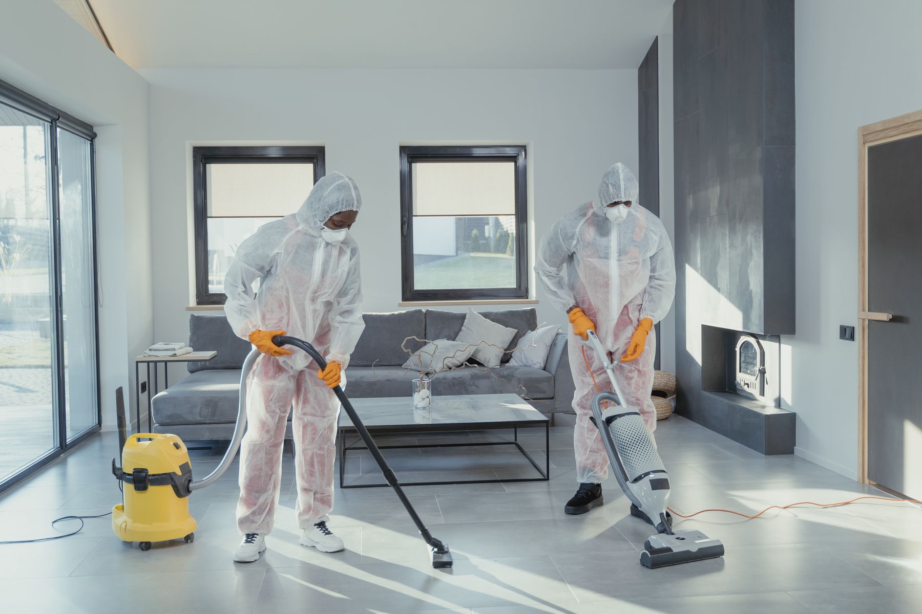 Professional cleaners vacuuming and sanitising a bright workplace