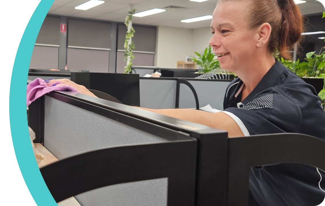 Flawless Clean team member wiping down an office workstation