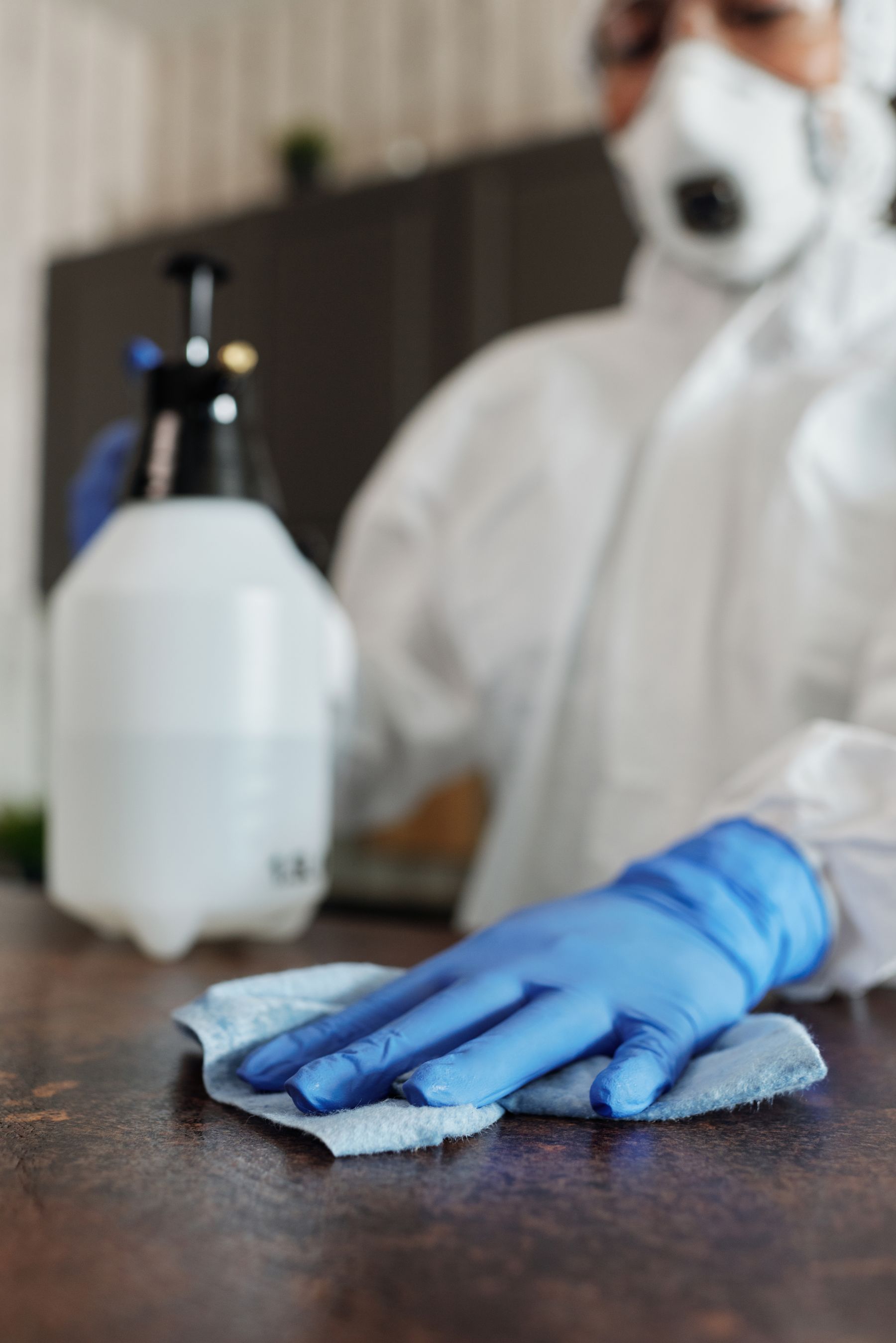 Protective cleaning equipment being used to disinfect a surface